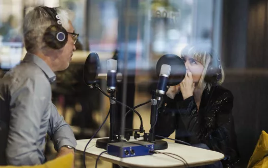 man and woman talking into microphones in a studio