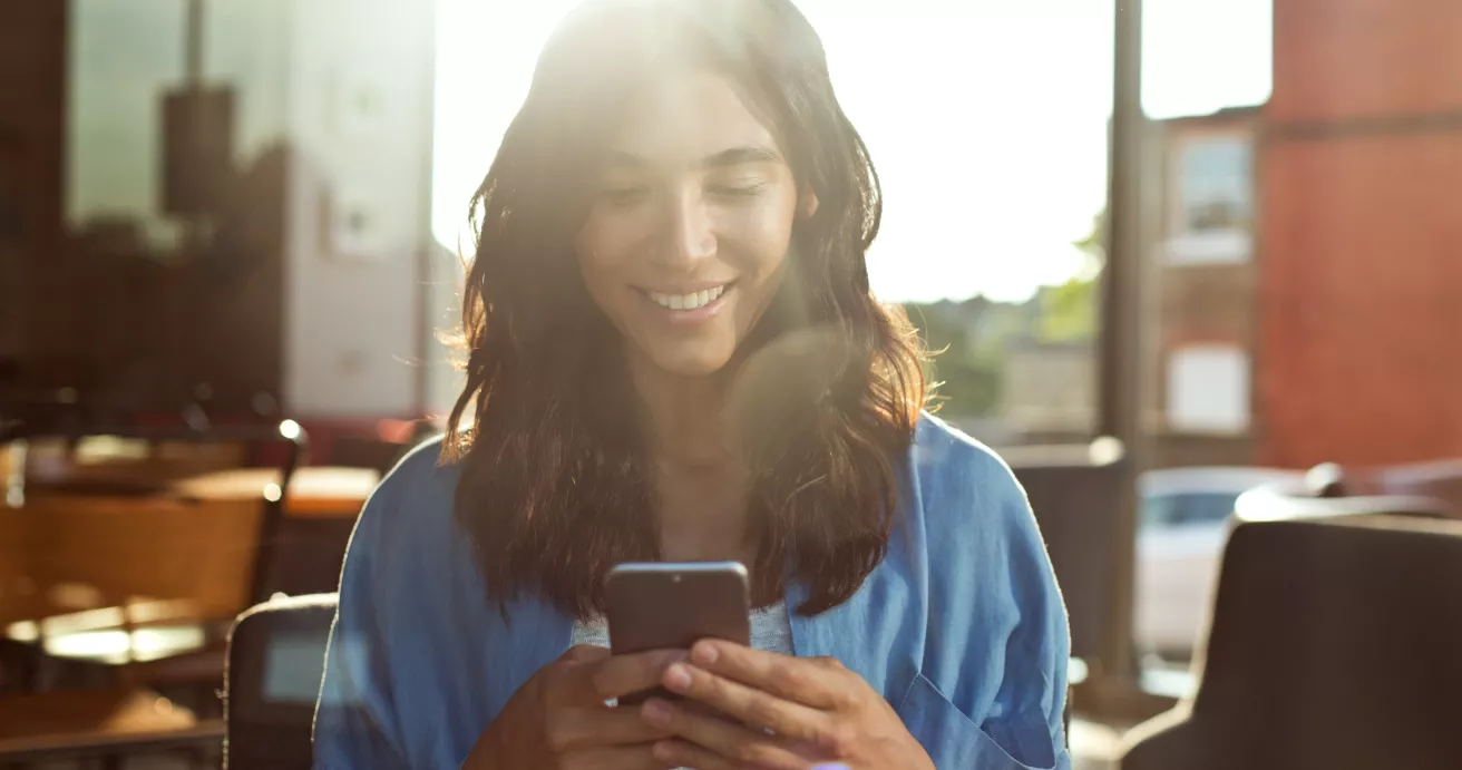 Young woman using mobile phone in coffee shop.