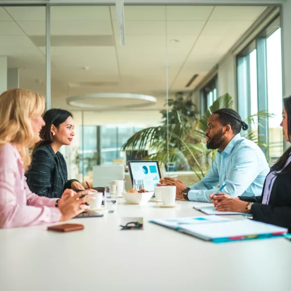 Four people in a meeting room.