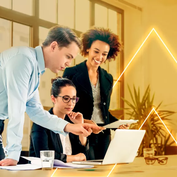 Three people gathered at a computer.