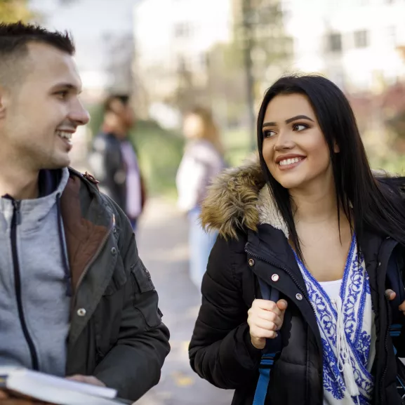 Group of college students walking on university campus.