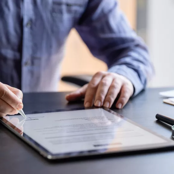 Businessman showing client where to sign document.