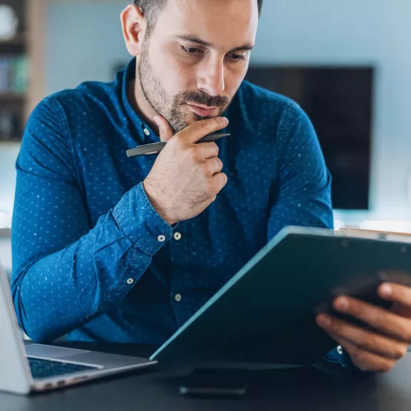 Young businessman working at home using lap top.