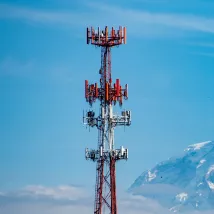 Radio tower with blue sky and mountains in the background
