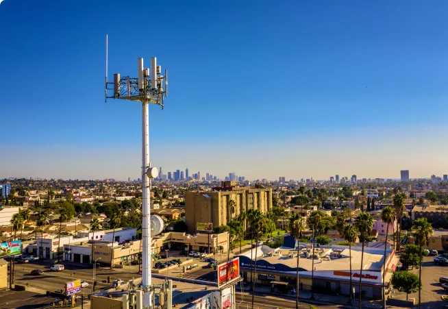 A cell tower in front of a city.