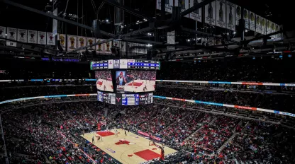 Basketball arena, with a large crowd and Jumbotron featuring the players on the court