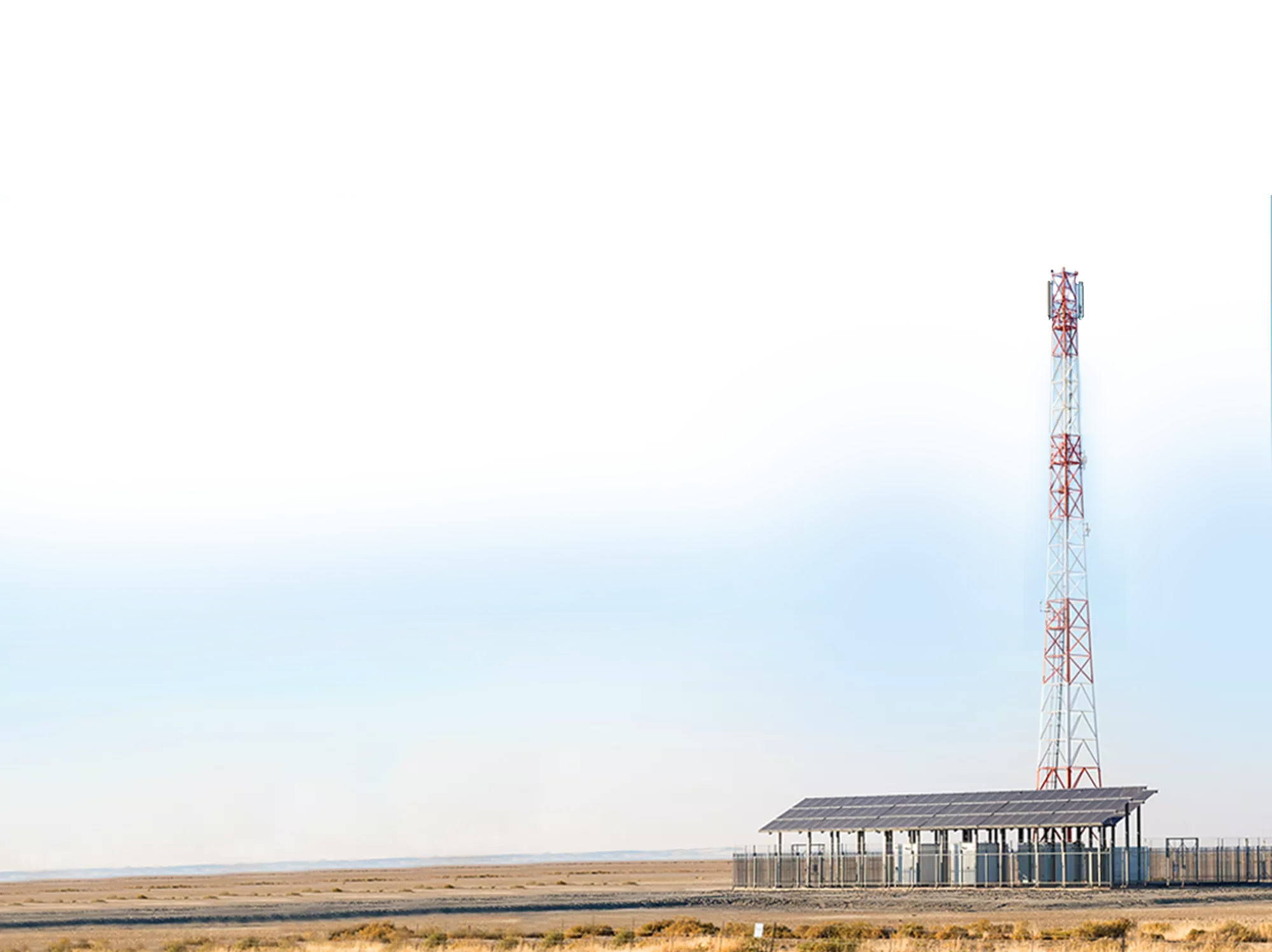 A cell tower on a landscape in Burkina Faso with solar panels.