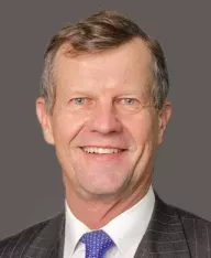 professional headshot of a man with a dark grey background