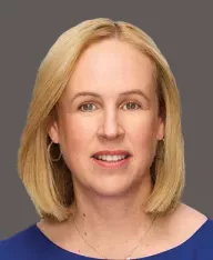 professional headshot of a woman with a dark grey background