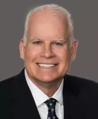 professional headshot of a man with a dark grey background