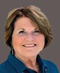 professional headshot of a woman with a dark grey background